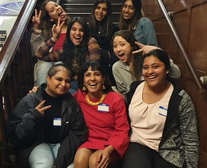 South Asian women sitting together on steps and smiling